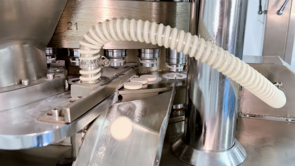 Tablets flowing from a continuous tablet press hopper