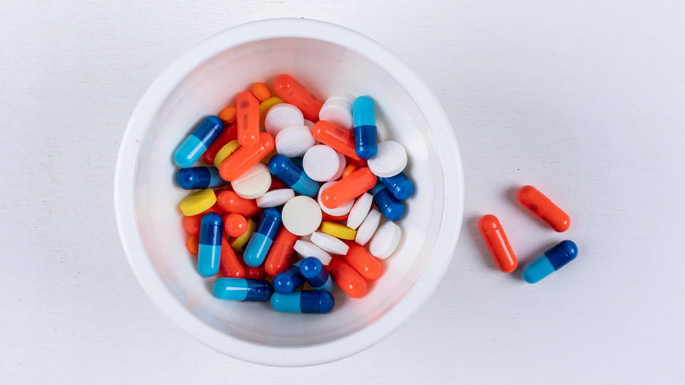 Colorful tablets and capsules in bowl