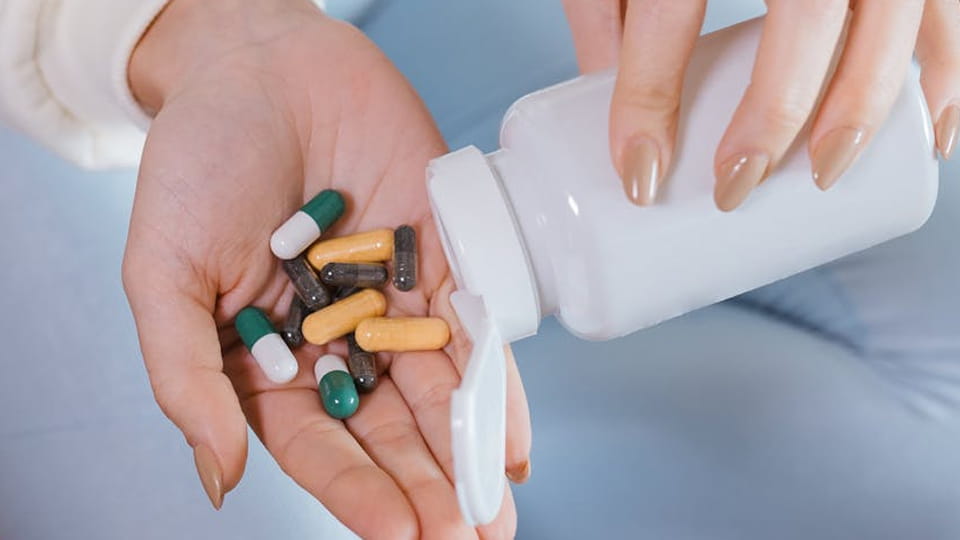 woman pours capsules from bottle