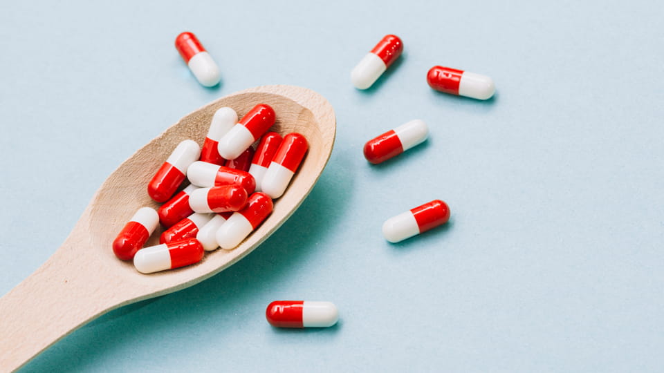 capsules on wooden spoon