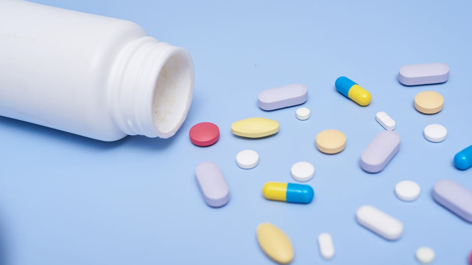 medical pills and tablets spilling out of a drug bottle