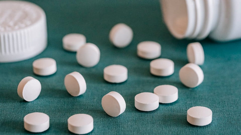 white tablets with pill bottle