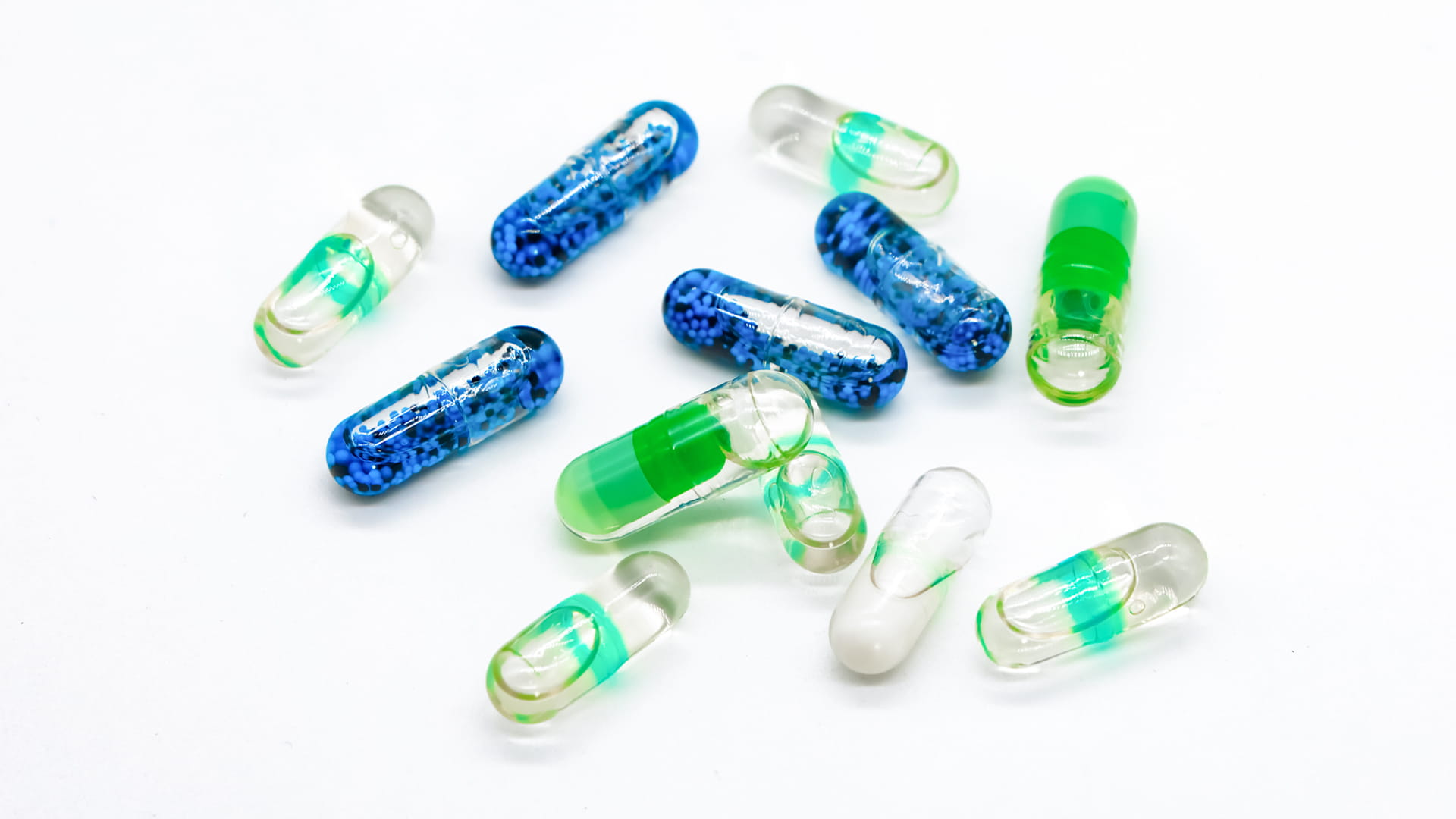 Liquid-filled hard capsules (each has a colored band sealing the cap-body joint)