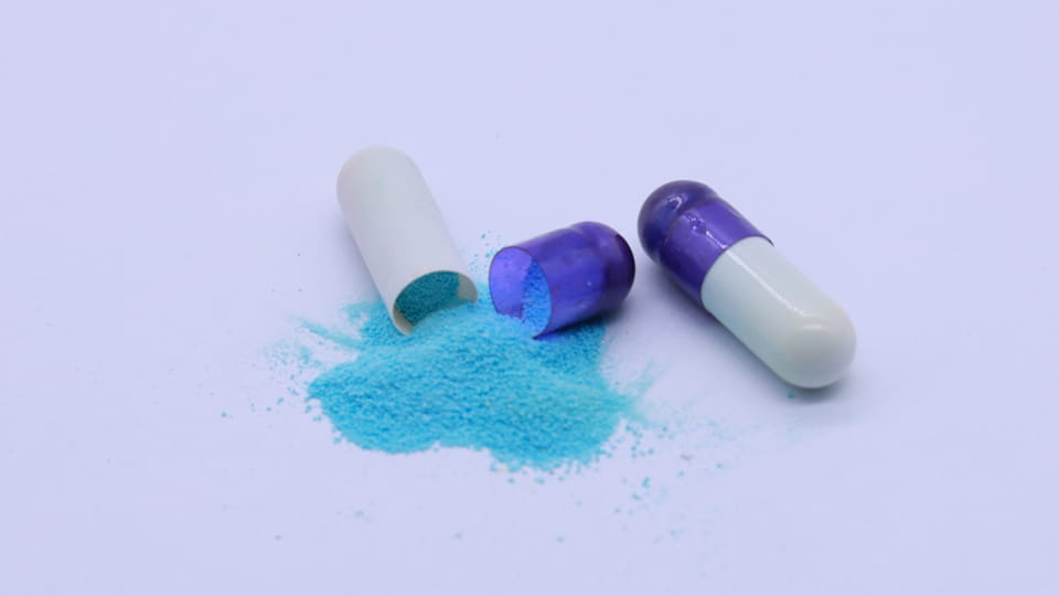 Capsule fill material exposed from hard capsules, showing how hygroscopic powder and moisture migration can affect capsule shell quality.