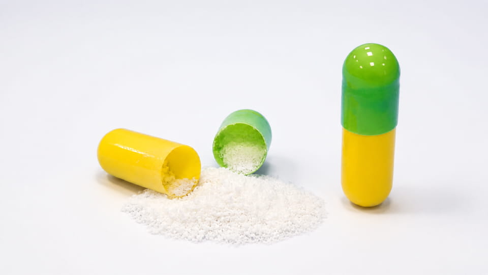 Powder formulation profile for capsule filling showing capsules and pharmaceutical powder before machine testing