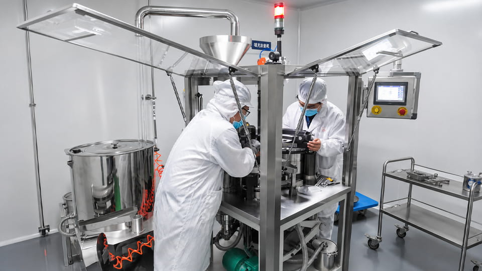 Technicians inspecting pharmaceutical equipment as part of a predictive maintenance program