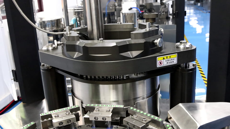 Close-up of an automatic capsule filling machine in operation, used to test filling compatibility with HPMC, pullulan and starch-based capsules.