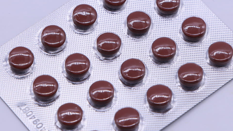 Round tablets seated in individual transparent blister cavities, illustrating product fit and clearance in pharmaceutical blister packaging.