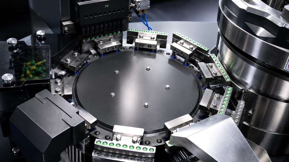 Rotary capsule filler with precision filling stations for verifying capsule fill weight during production.