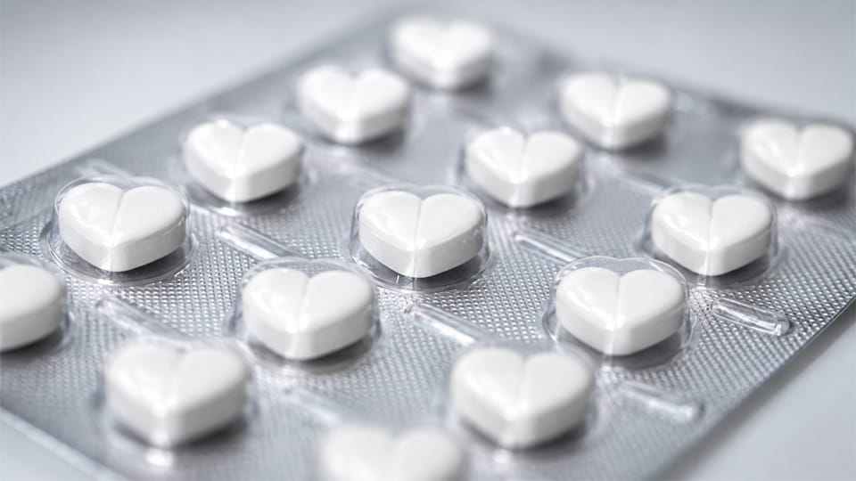 White heart-shaped tablets in clear pharmaceutical blister cavities, illustrating the importance of product shape and cavity fit in blister packaging.